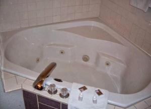 a bath tub in a bathroom with a towel at Western Holiday Motel in Wichita