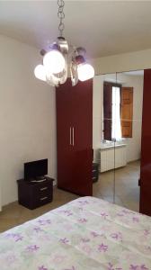 1 dormitorio con cama, espejo y lámpara de araña en Locanda il Cacciatore, en Pari
