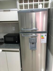 a stainless steel refrigerator in a kitchen with a microwave at Departamento Moritan in Posadas