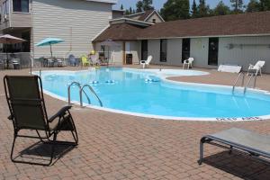 a swimming pool with a rocking chair at Sauble Beach Lodge in Sauble Beach