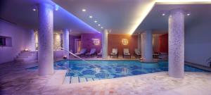 a pool in a hotel with columns and chairs at Campiglio Bellavista in Madonna di Campiglio