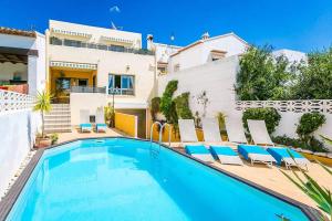 a villa with a swimming pool in front of a house at Fully Airconditioned Costa Blanca Pool House with Superb Views Over the Orba Valley, Sleeps 12 in Benimeli