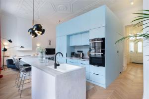 a kitchen with white cabinets and a large island at Erkel Boutique Apartment–Chic flat by Market Hall in Budapest