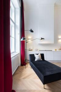 a living room with a black couch and a red curtain at Erkel Boutique Apartment–Chic flat by Market Hall in Budapest