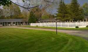 a white fence in front of a house at The Tallwood Motel in Wells