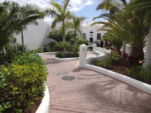 una passerella di fronte a un edificio bianco con palme di Bungalow Villa Sun a Playa Paraiso