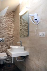 a bathroom with a sink and a toilet and a mirror at Gennadi Gardens exclusive apartments in Gennadi