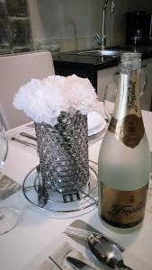 - une bouteille de champagne et un vase de fleurs sur une table dans l'établissement Apartment Brane, à Solin