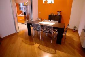 einen Esstisch und Stühle mit orangefarbener Wand in der Unterkunft b&b la mondina in Palazzolo Vercellese