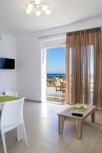 a living room with a table and a view of the ocean at Gennadi Gardens exclusive apartments in Gennadi