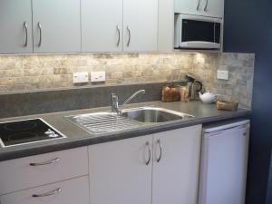 a kitchen counter with a sink and a microwave at Molyneux House in Kaka Point