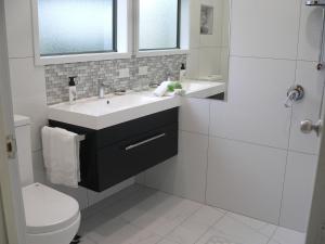 uma casa de banho com um lavatório e um WC em Molyneux House em Kaka Point