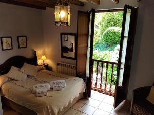 a bedroom with a bed and a door to a balcony at Trisqueles y Buganvillas in Villaviciosa