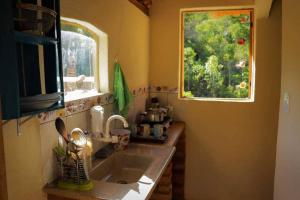 a kitchen with a sink and a window at Hospedagem Brilho da Lua in Divino de São Lourenço