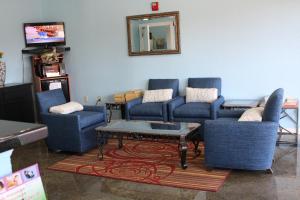 sala de estar con sillas azules y mesa de centro en Budget Inn Pasadena, en Pasadena
