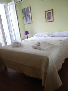 1 dormitorio con 1 cama blanca grande y toallas. en Appartamento in rue Halevy, en Niza