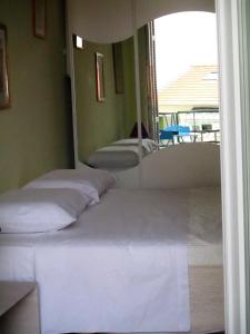 Cette chambre comprend 3 lits et un grand miroir. dans l'établissement Appartamento in rue Halevy, à Nice