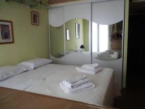 Una habitación con espejo y toallas en una mesa. en Appartamento in rue Halevy en Niza