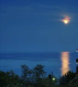 a full moon over the ocean at night at Afytos Dream suites sea view in Afitos