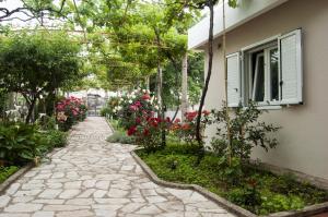 a stone walkway in front of a house with flowers at Little Nautilus in Tivat