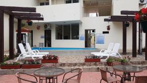 eine Gruppe von Stühlen und Tischen vor einem Pool in der Unterkunft Playa Aventura Hotel in Ayangue