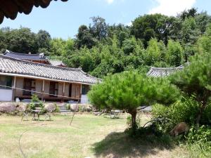 un edificio con sillas y árboles en un patio en Suncheonbay Stay en Suncheon