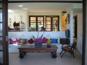 a living room with a couch with colorful pillows at Villa Bidadari Kutuh Nusa Dua in Nusa Dua