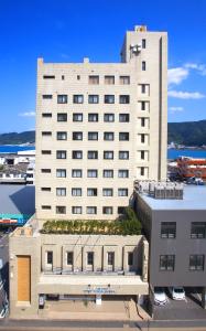 a large white building with a lot of windows at Amami Port Tower Hotel in Amami