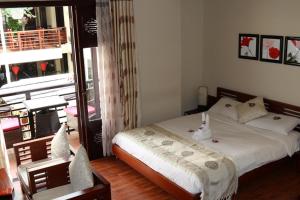 1 dormitorio con 1 cama y balcón en Long Life Riverside Hotel, en Hoi An