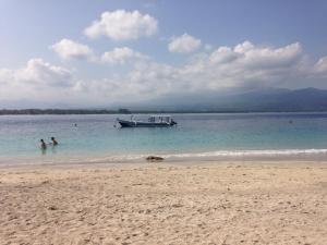 ein Boot im Wasser am Strand in der Unterkunft Blu d'aMare in Gili Trawangan