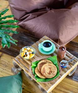 una bandeja con panqueques y una taza de café sobre una mesa en Bamboo & B en Licin