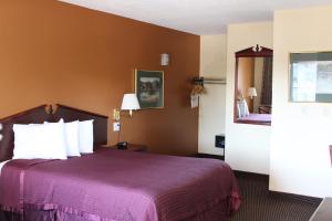 a hotel room with a bed with a purple bedspread at Knights Inn Salem in Salem