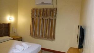 a hotel room with a bed and a television at Jeamco Royal Hotel-Cotabato in Cotabato