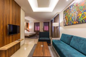 a living room with a couch and a tv at Great Diponegoro Hotel Surabaya in Surabaya