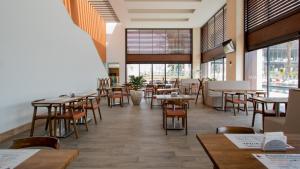 - une salle à manger avec des tables, des chaises et des fenêtres dans l'établissement Miyana Luxury Studio, à Mexico