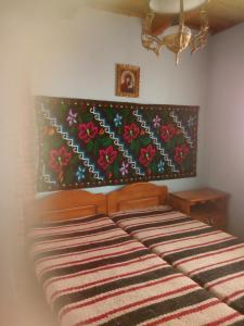 BotizaにあるCasa Poienarのベッドルーム1室(花柄のヘッドボード付きのベッド1台付)