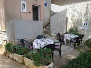 a patio with tables and chairs in a courtyard at Apartment Romana in Ilovik