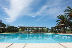 una piscina en un complejo con palmeras en Hotel Parque Oceánico, en La Coronilla