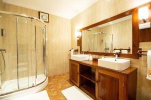 La salle de bains est pourvue de 2 lavabos, d'une douche et d'un miroir. dans l'établissement Mediterraneo Boutique Hotel, à Dar es Salaam