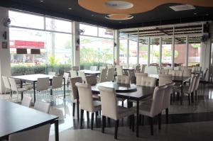 a dining room with tables and chairs and windows at BK Place Hotel in Bung Kan