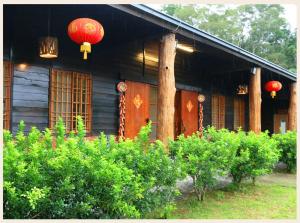 uma casa com lanternas vermelhas ao lado em 初鹿敦親牧鄰民宿 em Chulu