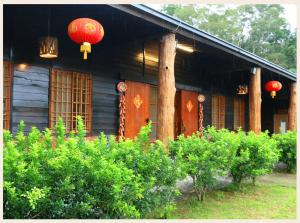 una casa con linternas rojas a un lado. en 初鹿敦親牧鄰民宿, en Chulu
