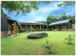 un edificio con una gran roca en un patio en 初鹿敦親牧鄰民宿, en Chulu