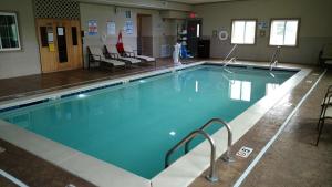 a large swimming pool with blue water in a building at Best Western Plus Crawfordsville Hotel in Crawfordsville