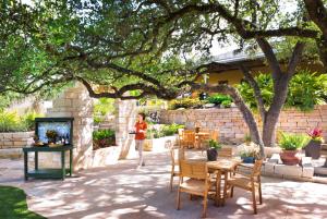 a woman walking through a patio with a table and chairs at Hyatt Vacation Club at Wild Oak Ranch in San Antonio
