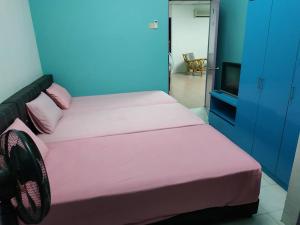 a bedroom with a bed with pink sheets and a tv at Formosa Hotel in Malacca