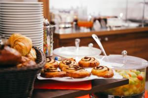 a table topped with plates filled with donuts at Stadthotel Hamburg in Hamburg
