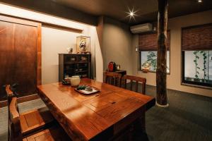 a dining room with a wooden table and chairs at Hazuki Kyoto in Kyoto