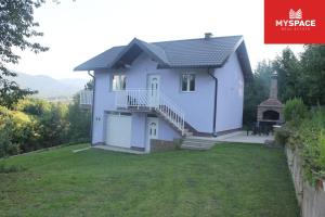 a house with a garage and a yard at Vacation home Djogic in Ilidza