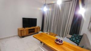 a living room with a television and a wooden table at OpenSky Lux in Kallithea Halkidikis